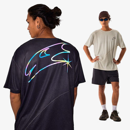 Person wearing a black t-shirt with colorful design on the back, standing next to another person in a beige t-shirt and black shorts.